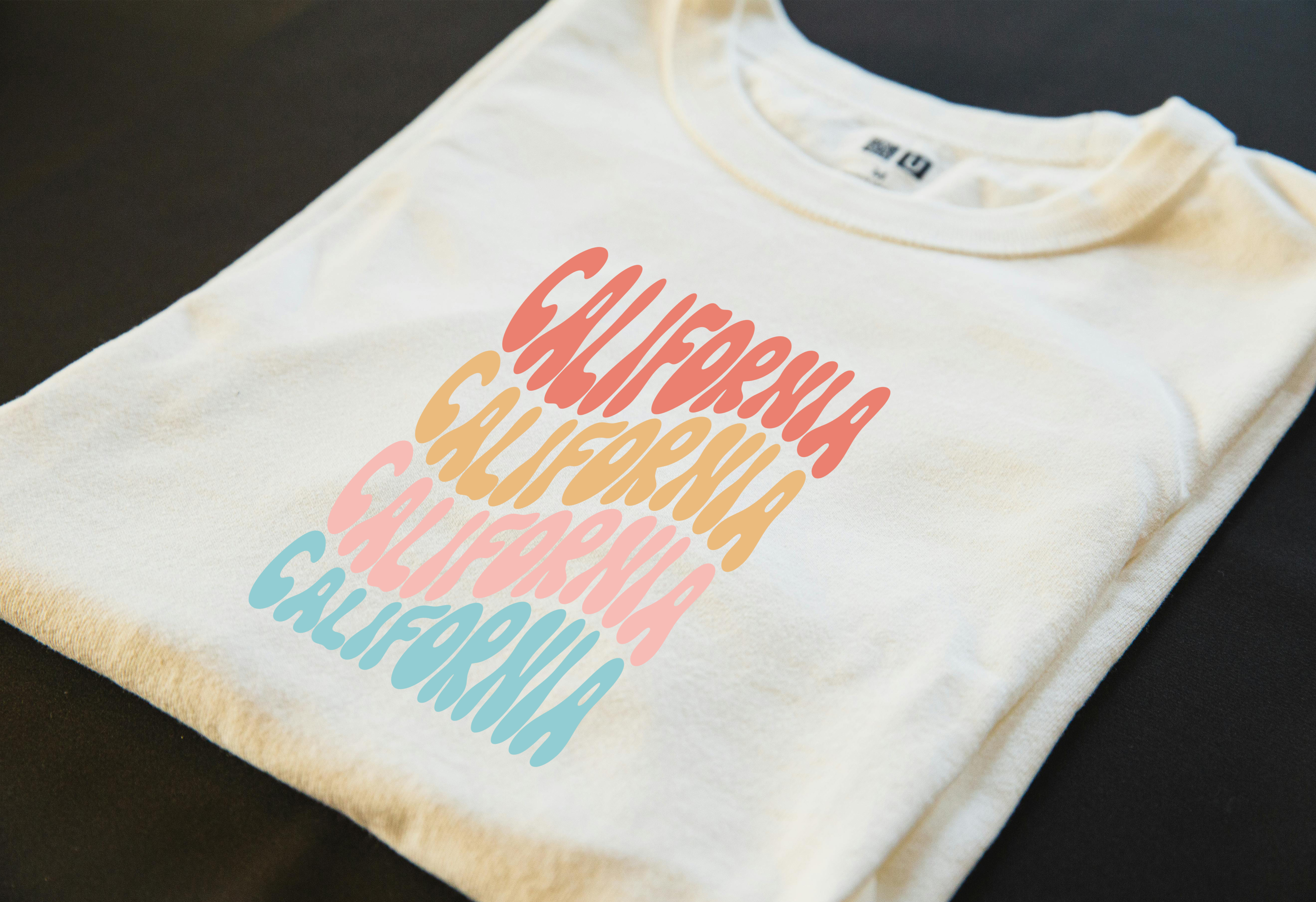 Folded white T-shirt featuring colorful stacked 'California' text on the front