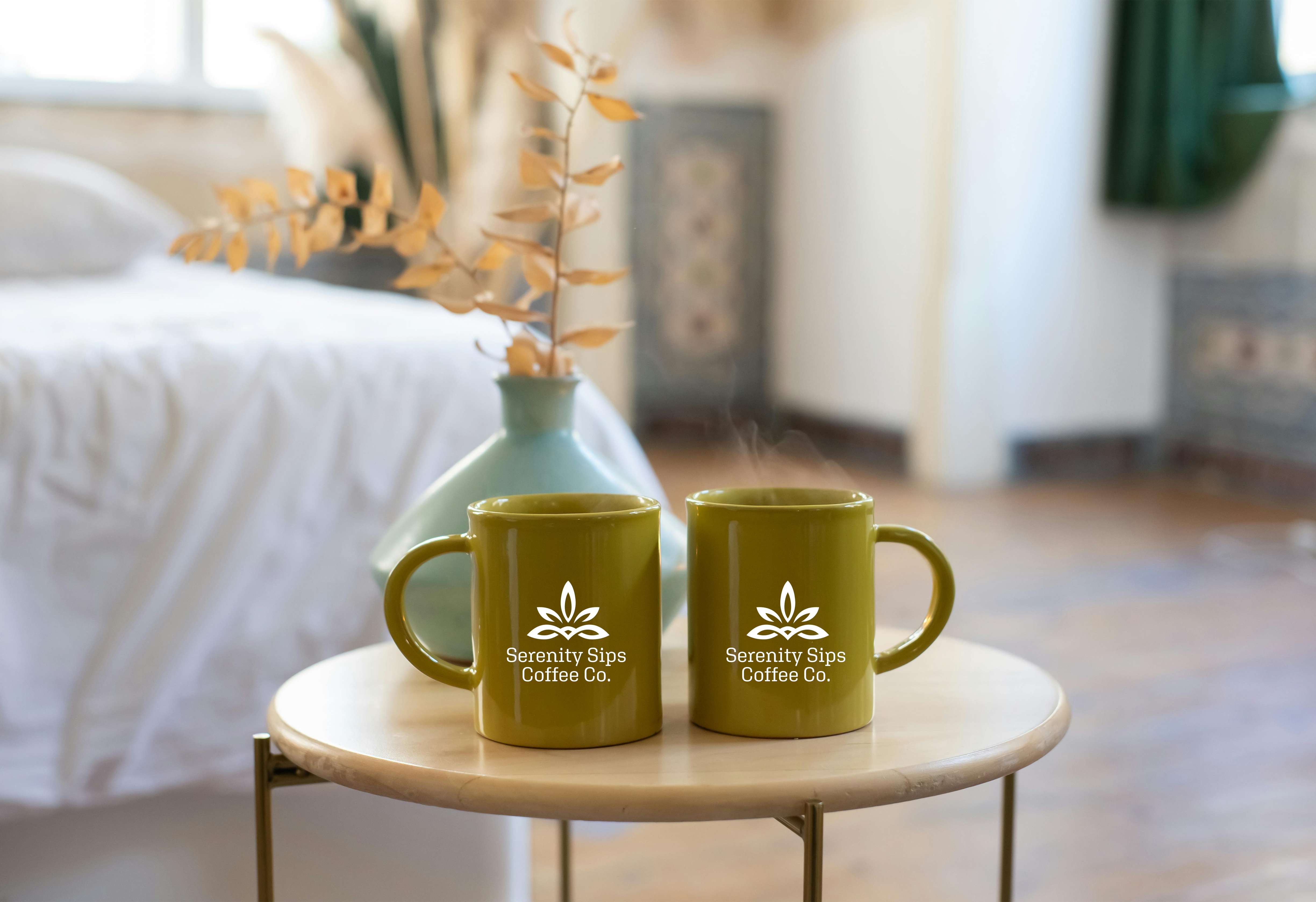 Two mugs with cuastom printed logos sitting on wooden coffee table next to vase